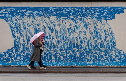 A woman walking down the street with an umbrella