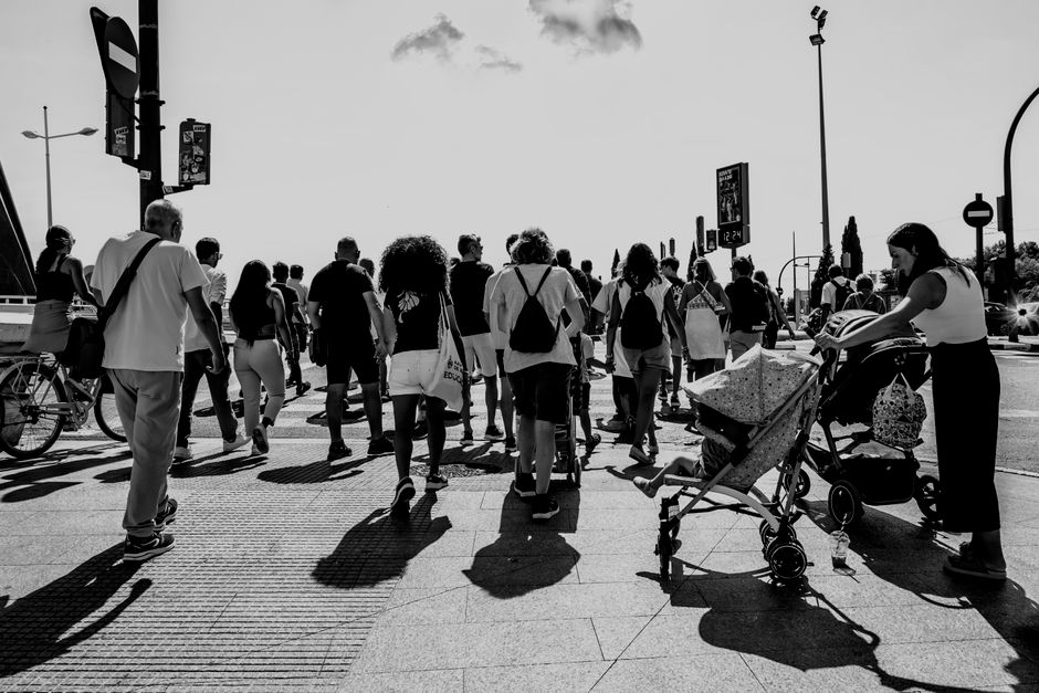 Fotografía cautivadora en blanco y negro de peatones caminando por una calle concurrida en Valencia, España.