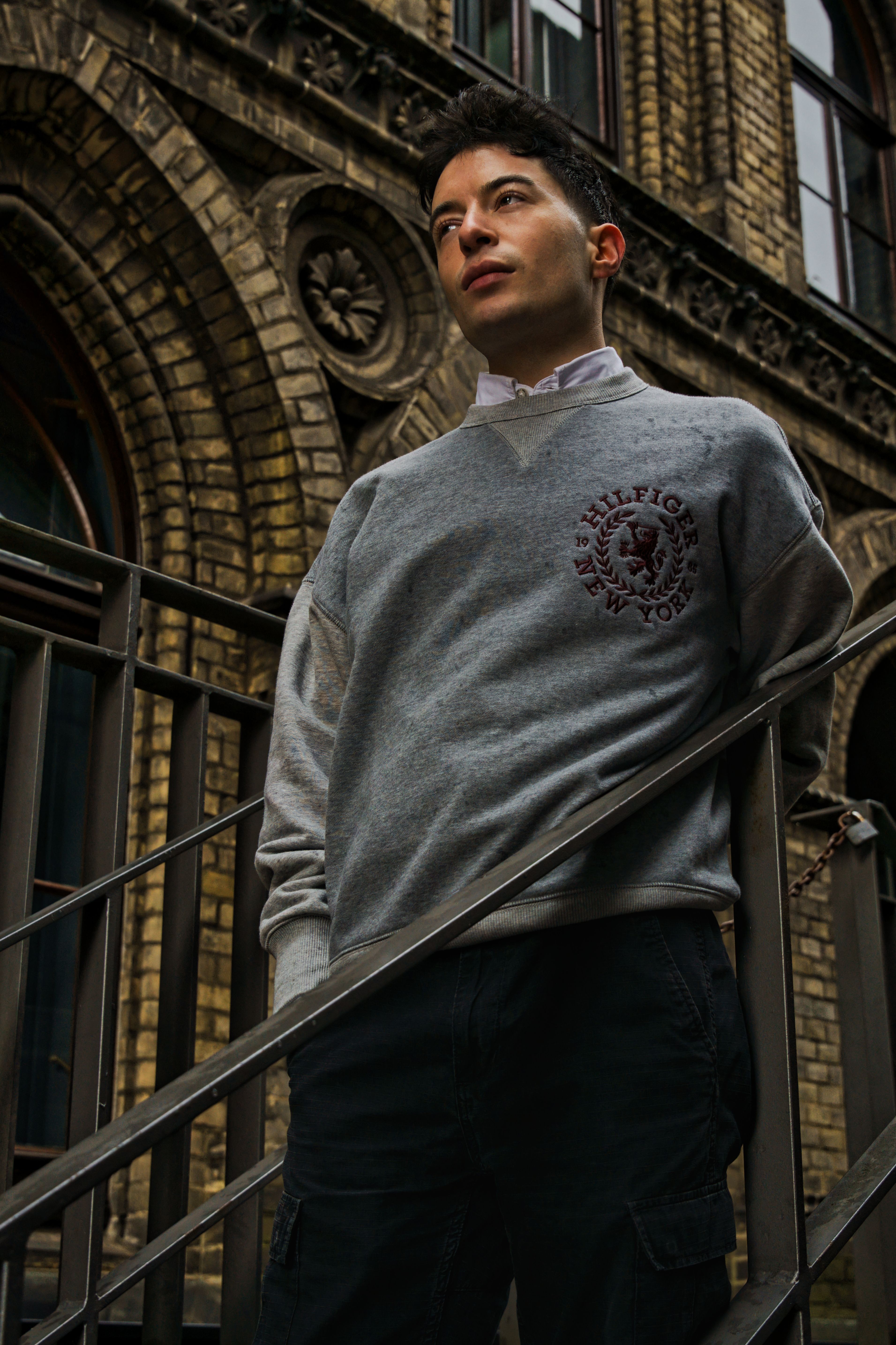 Stylish portrait of a man leaning on a railing with historic architecture in Bremen, Germany.