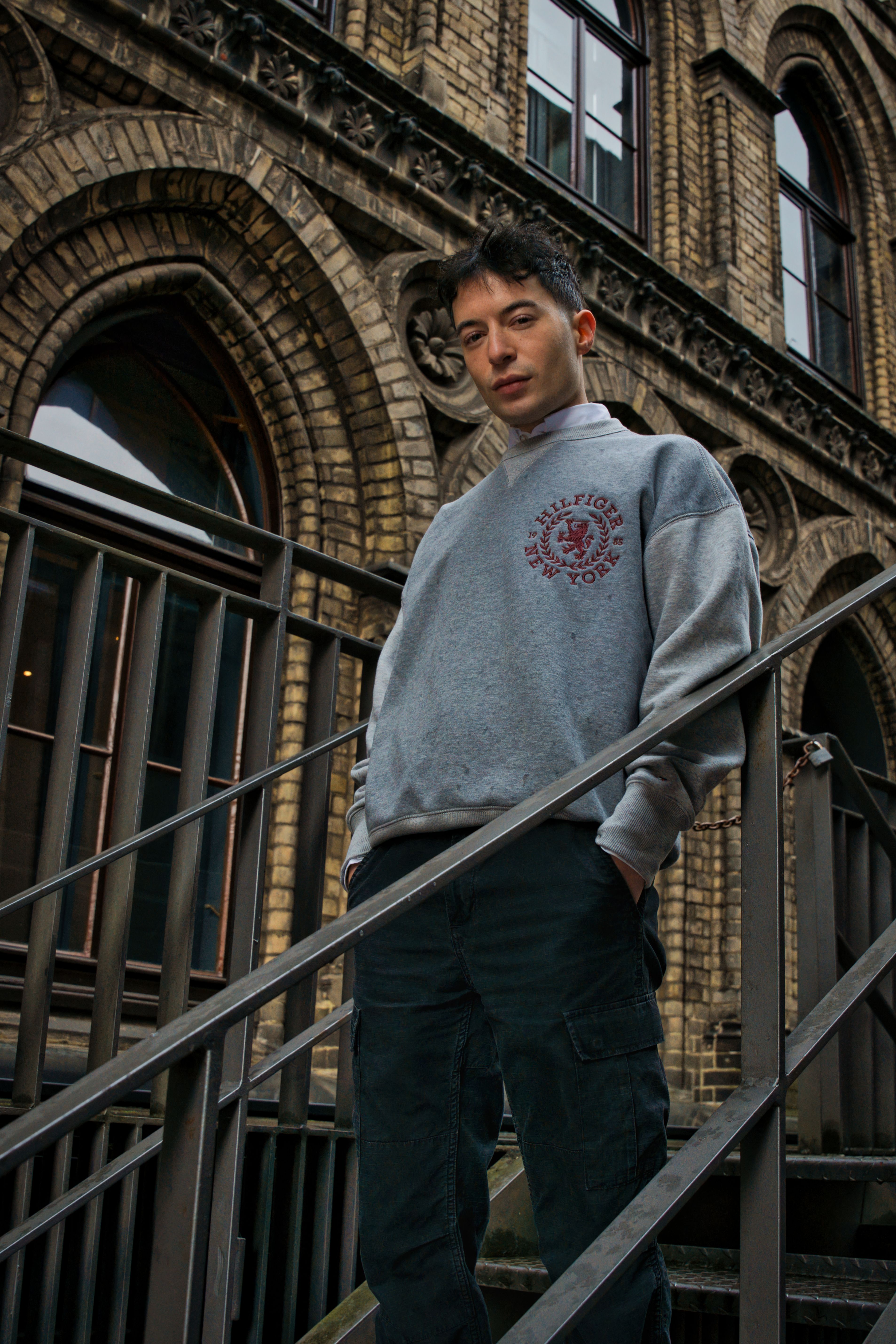 Portrait of a young man standing on a staircase with historical Bremen architecture in the background.