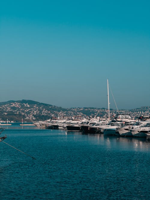 A boat docked in a harbor with mountains in the background