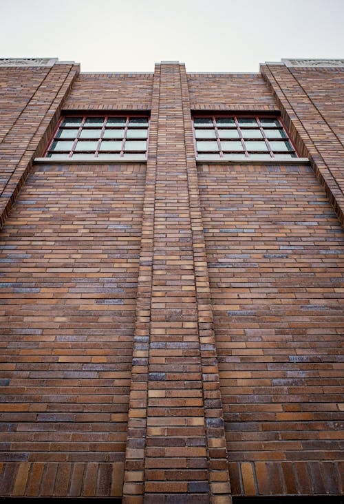 A brick building with windows and a sky