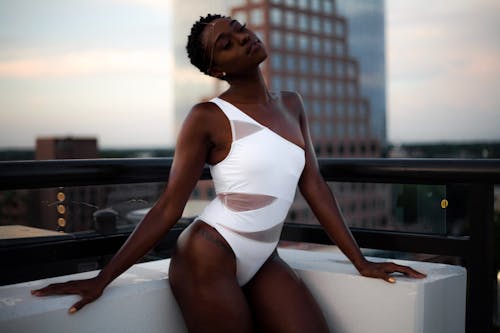 Free A woman in a one piece swimsuit on a rooftop Stock Photo