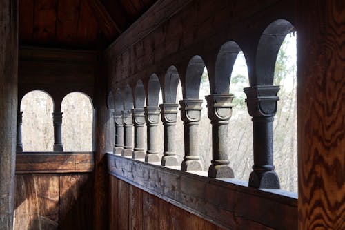 彫刻が施された柱のあるノルウェーの木造スターヴ教会の外部廊下