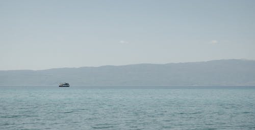 A boat is floating in the water near mountains