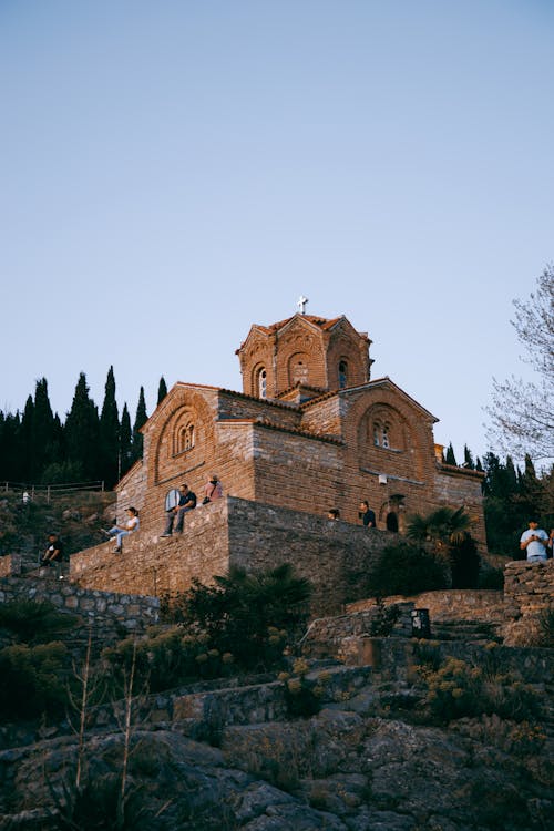 A church on top of a hill with people walking around it