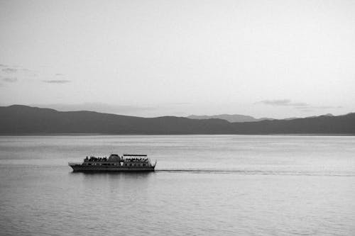 Free A boat on the water with mountains in the background Stock Photo