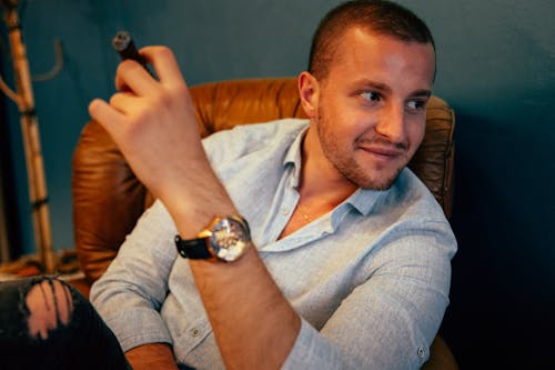 A man in a blue shirt is sitting on a chair