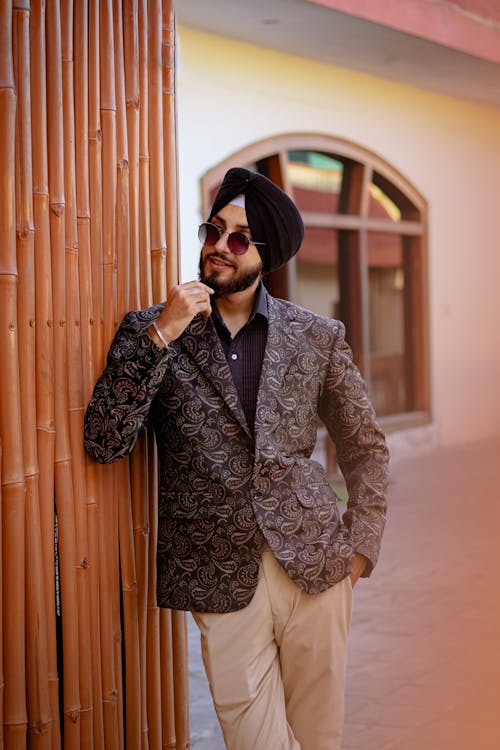 A man in a suit leaning against a wall