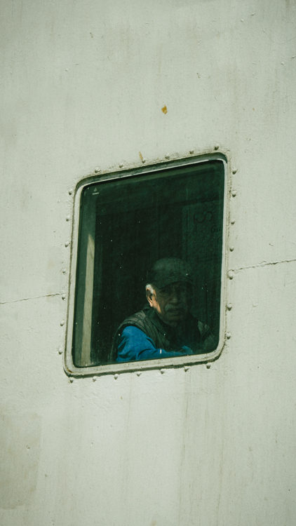 Free Senior man with gray hair looks out a ship window in Büyükada, İstanbul. Stock Photo