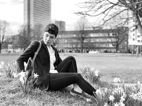 Free Woman Sitting among Flowers at Park Stock Photo