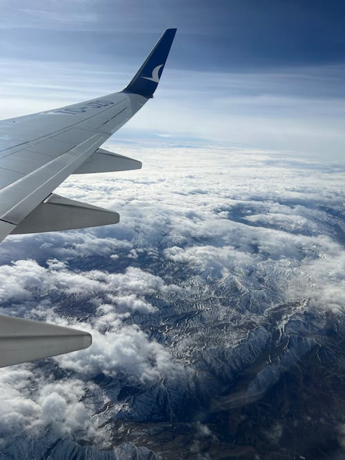 A view of the wing of an airplane flying over the clouds