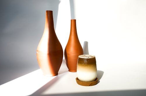 A cup and two vases on a table