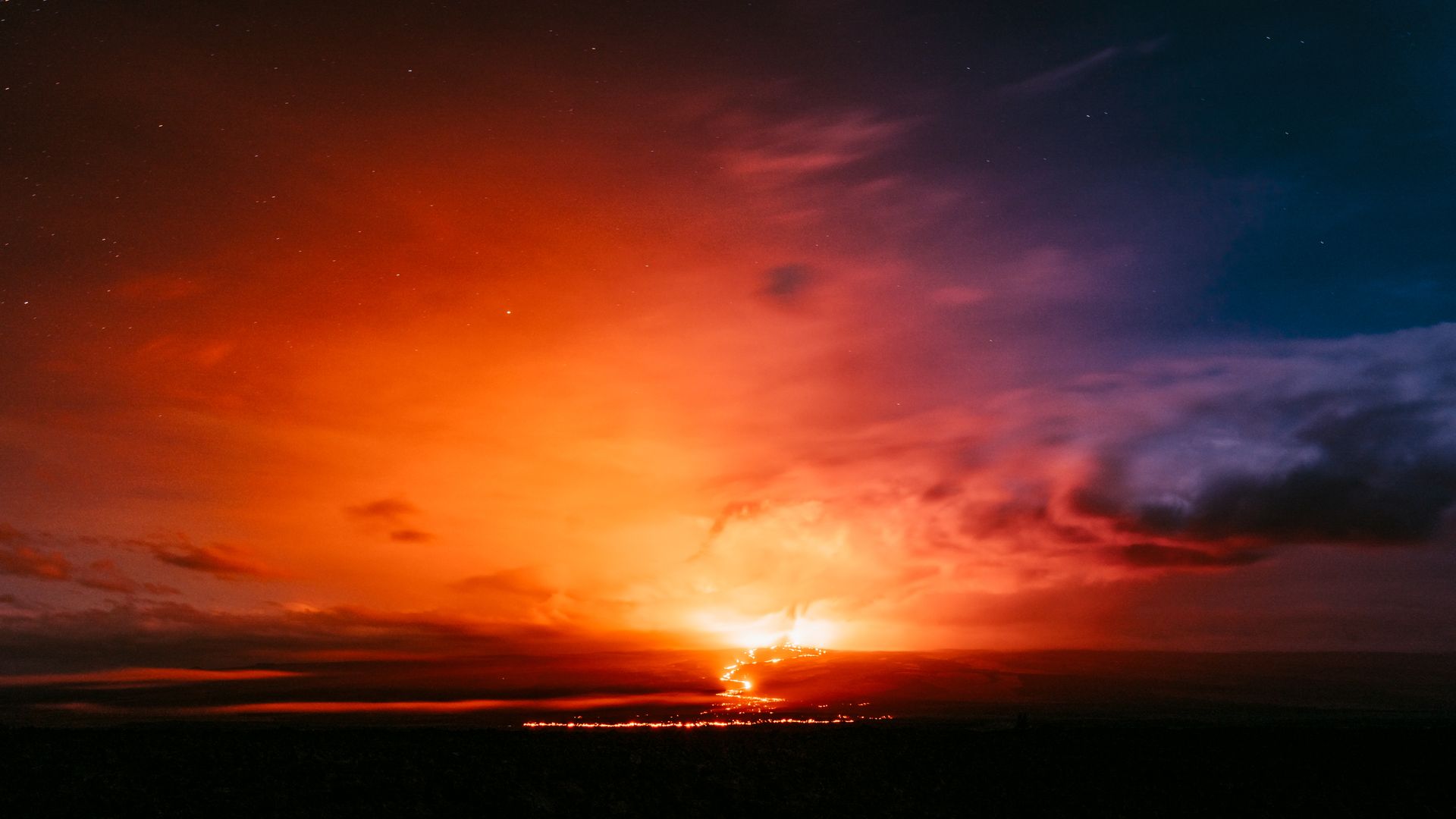 A breathtaking view of Mauna Loa erupting at night, lighting up the sky in Hawaii.