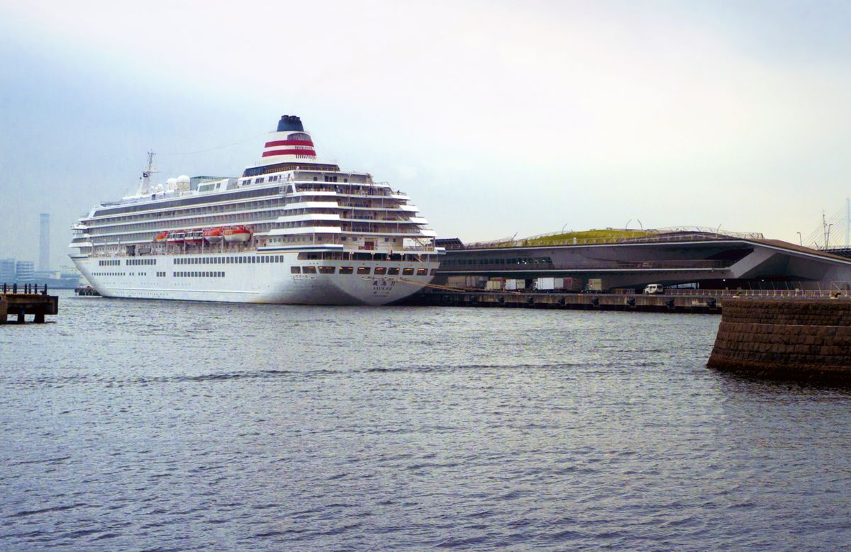 A large cruise ship docked at Yokohama port beside the modern Osanbashi terminal building