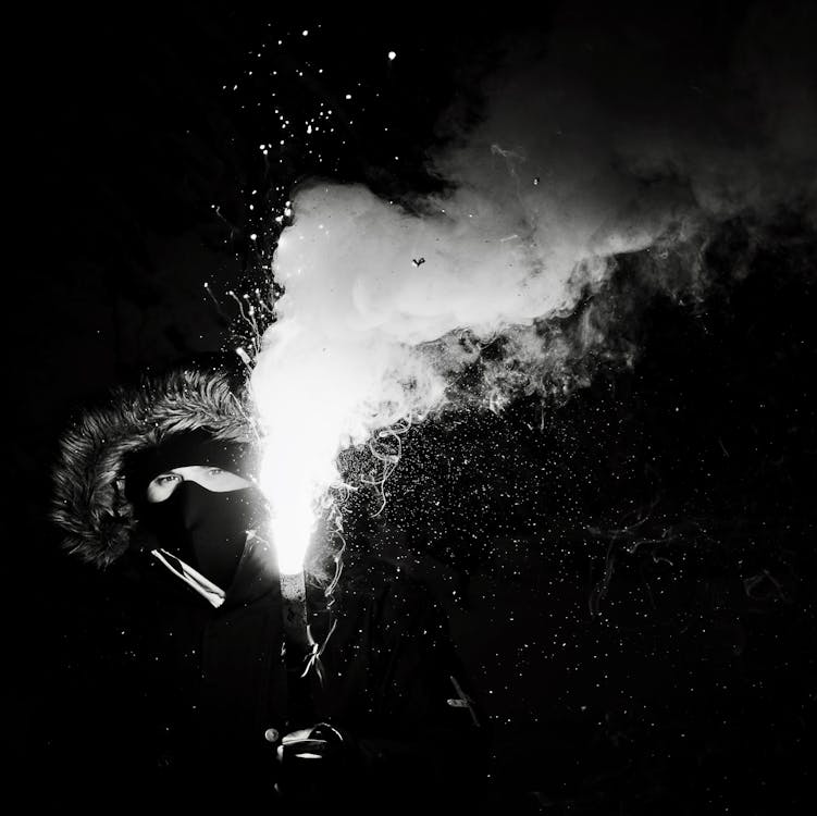 Grayscale Photography of Person Holding Flare