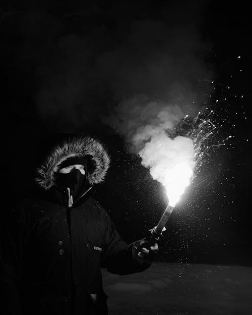 Person Wearing Coat Holding Firework