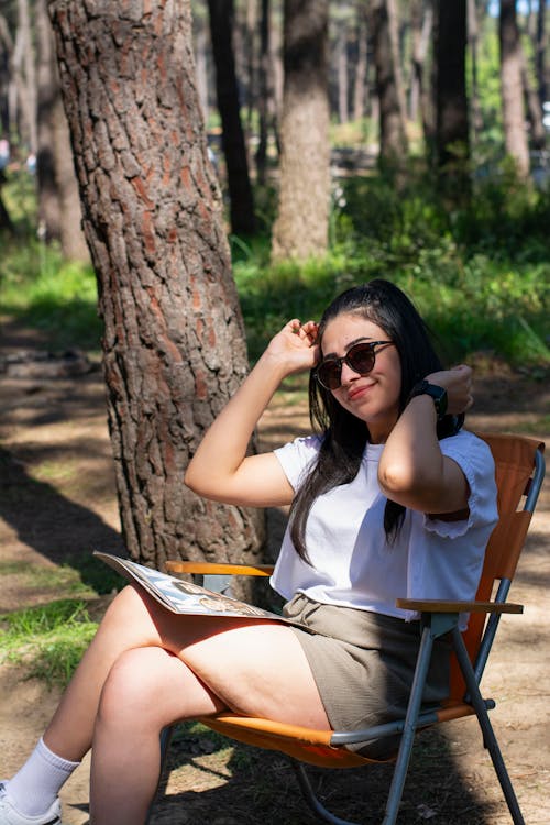 Free A woman sitting in a chair in the woods Stock Photo