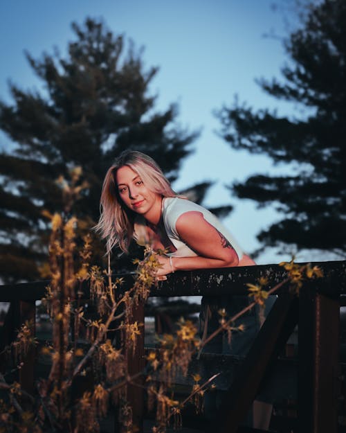 Free A beautiful blonde woman leaning on a fence Stock Photo