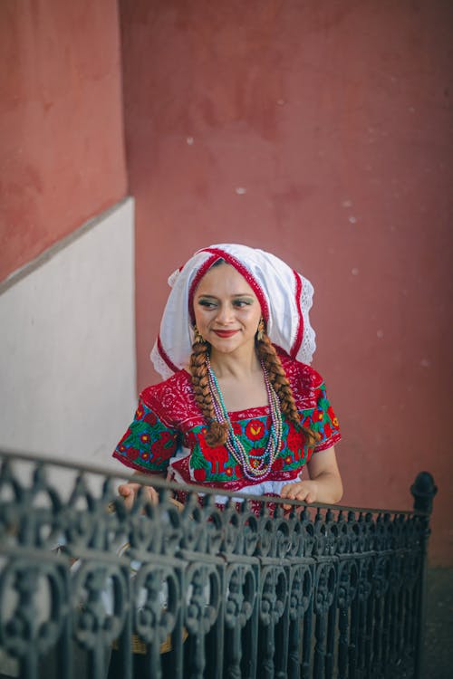 Free A woman in traditional clothing is standing on a railing Stock Photo