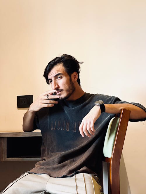 Free A man sitting at a desk drinking coffee Stock Photo