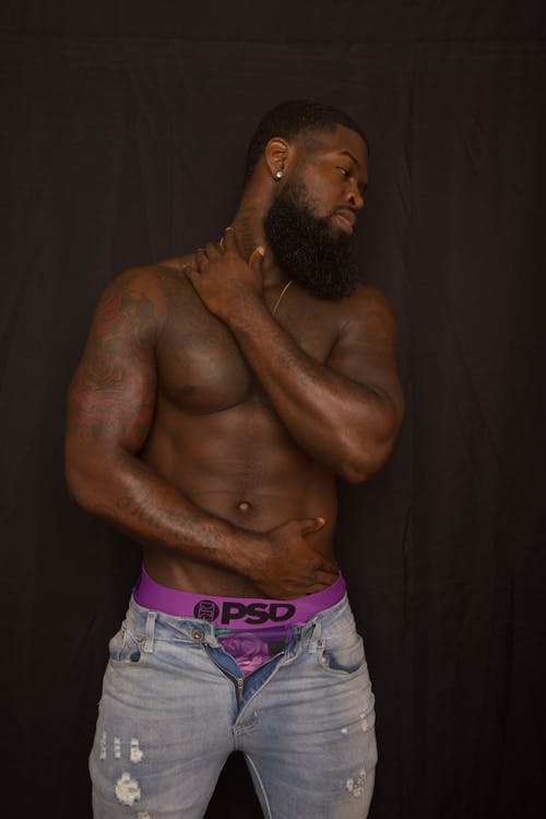 A man with tattoos and a purple waistband