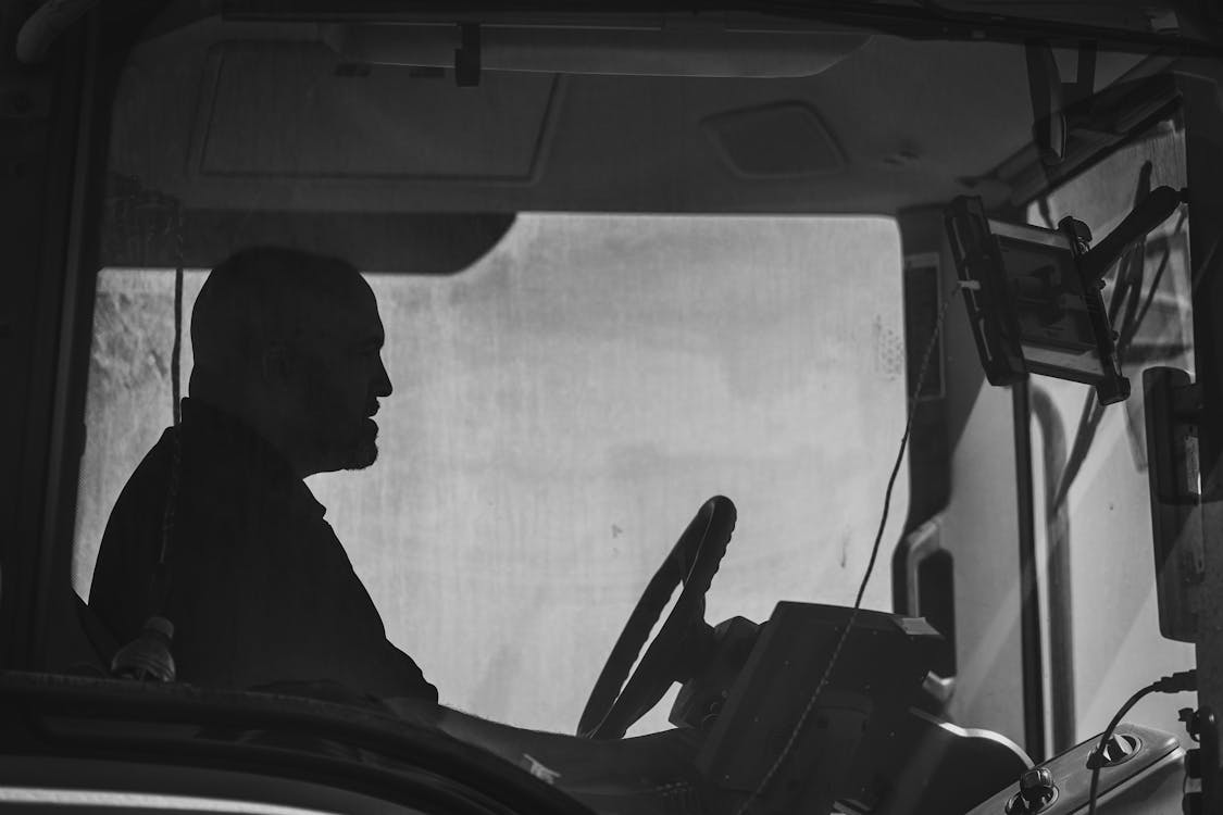 Free A man driving a tractor in black and white Stock Photo