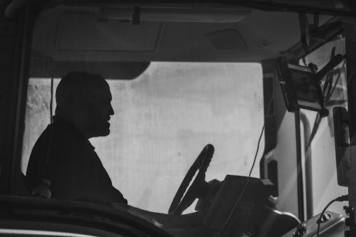 Free A man driving a tractor in black and white Stock Photo