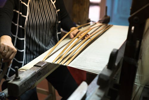 Woman Weaving Brown Wooden Mat