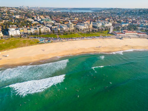 An aerial view of a beach and surfers