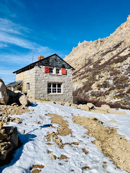 A small stone house sits on top of a mountain