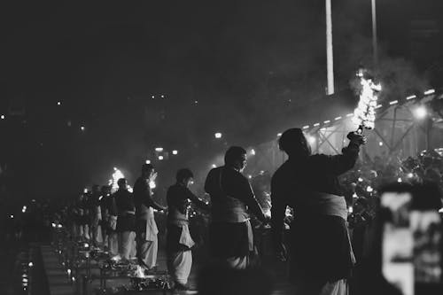 Black and white photo of people holding torches