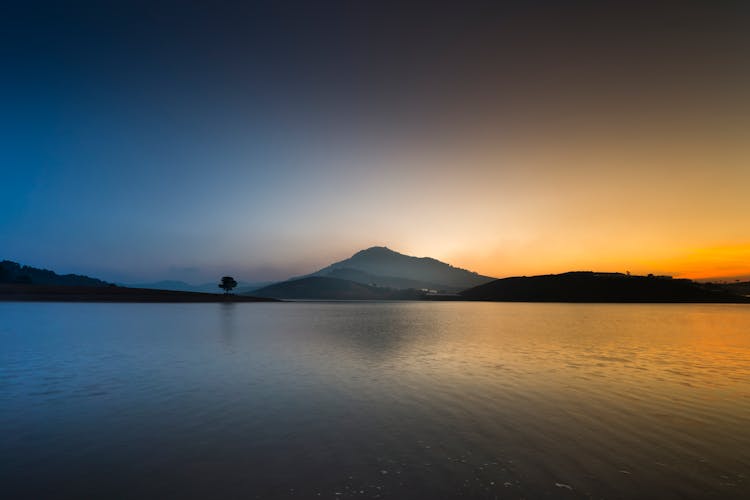 Calm Body Of Water Near Mountain View