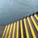 黄色的楼梯向下延伸，没入平静的河水，呈现出一派宁静的景象