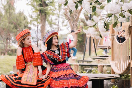 Free Two women in traditional costumes sitting on a bench Stock Photo