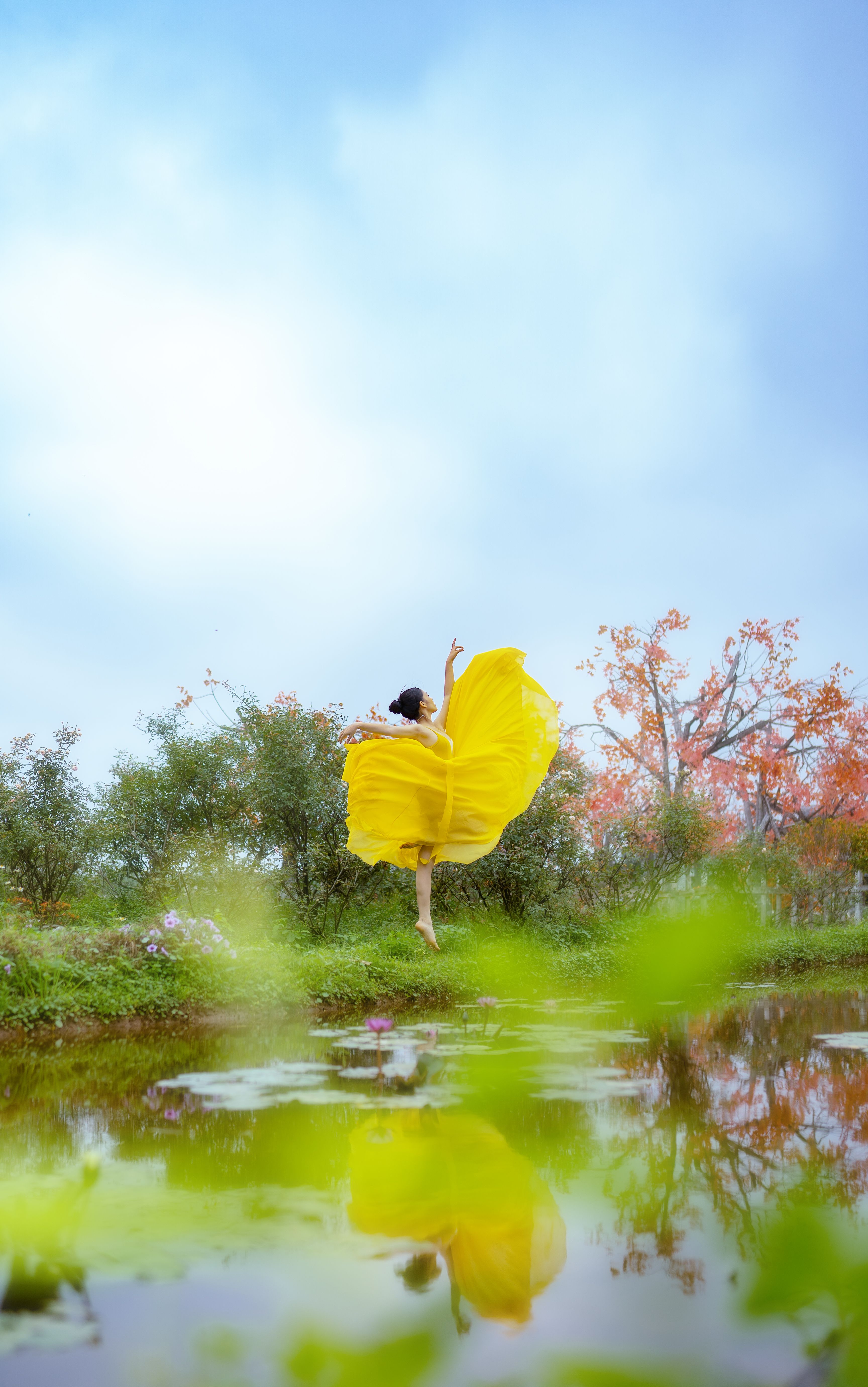 Brunette Woman in Yellow Dress Jumping in Garden · Free Stock Photo