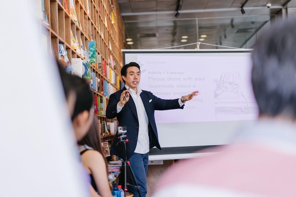 man in suit talking in front of the people confidently