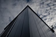 从下方拍摄的未来派建筑与天空中戏剧性的云层相映成趣