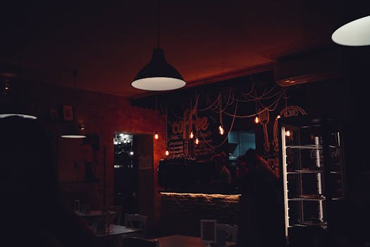 咖啡店内部光线温暖舒适，配有吊灯和黑板装饰