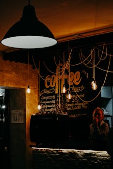 这家咖啡馆内部灯光温暖，设有悬挂灯泡和黑板菜单