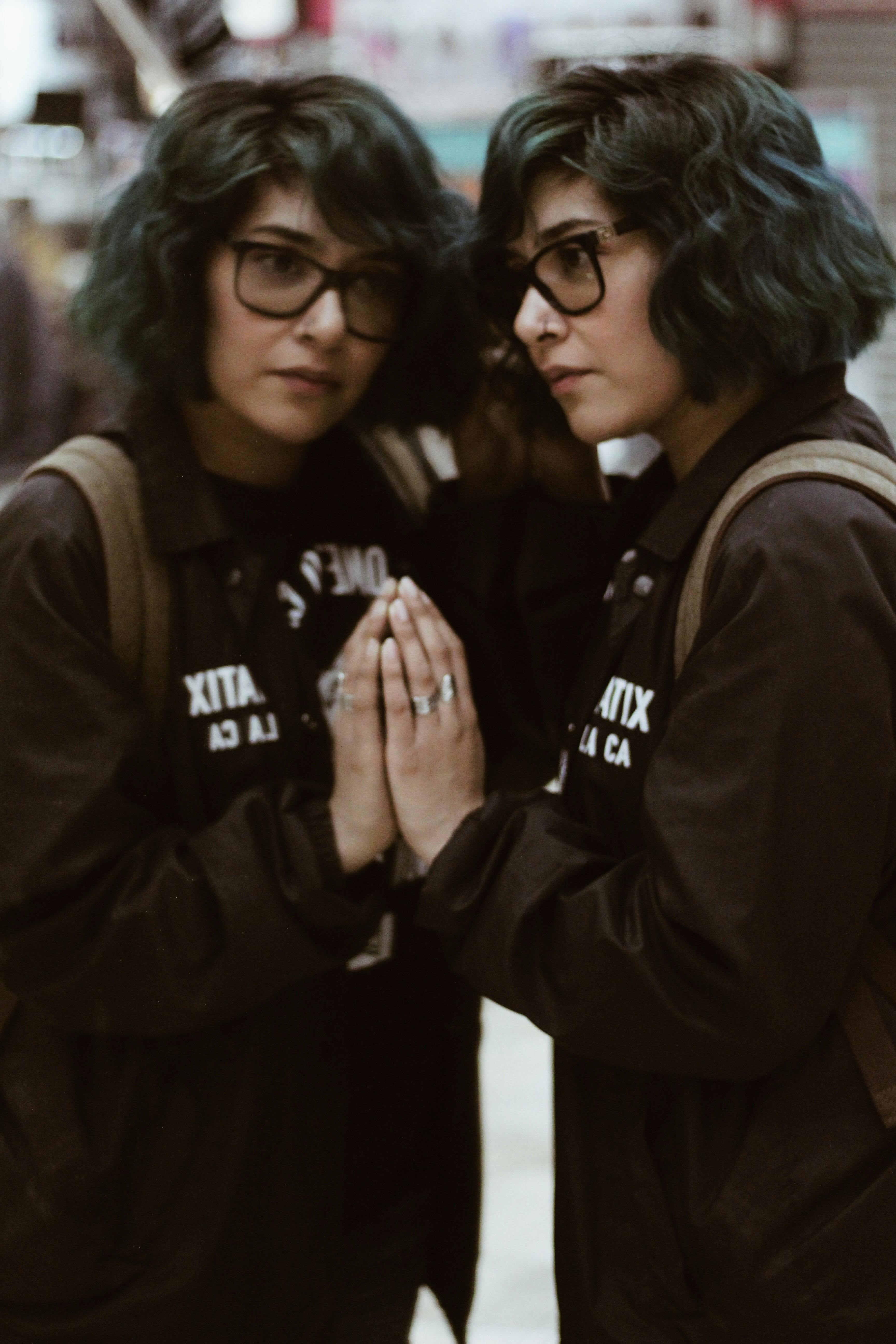 画中是一位戴着时尚眼镜、留着蓝绿色头发的女性