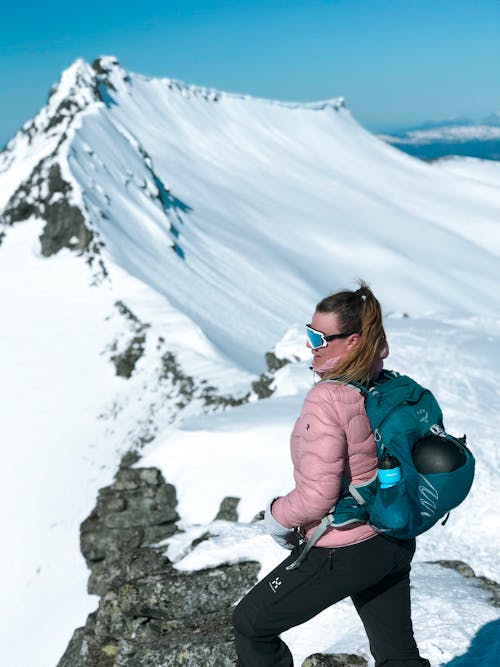 無料 雪をかぶった山の頂上にいる女性の写真 写真素材