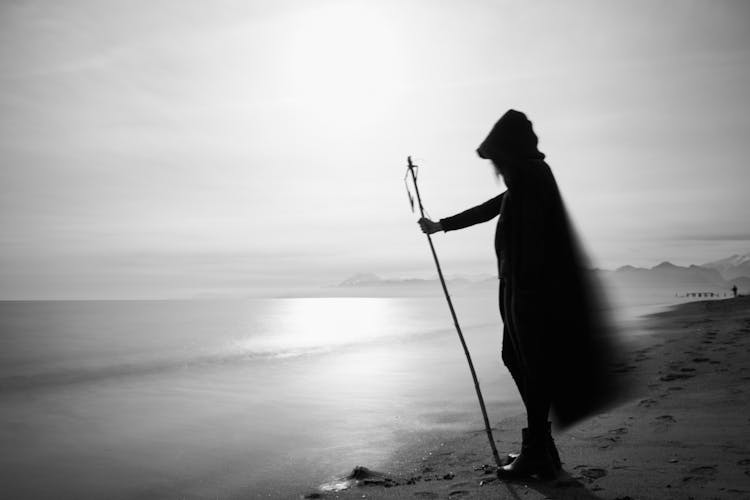 Silhouette Of Person Standing Near Calm Sea