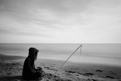 Free Silhouette of Woman With Fishing Pole Sitting on Bech Stock Photo