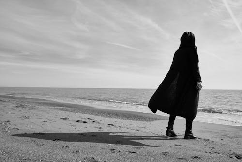 Free Grayscale Photo of Person Standing on Seashore Stock Photo