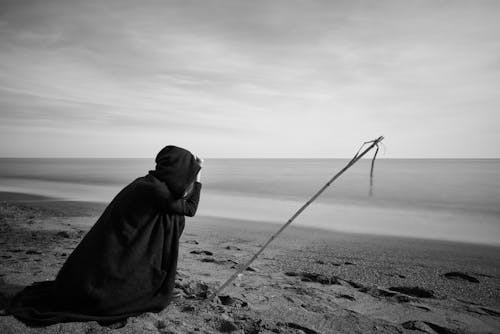 Person Near Seashore Grayscale Photo