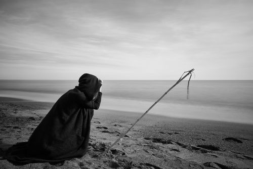 Free Black and white image of a person in solitude on a serene beach, emphasizing introspection. Stock Photo