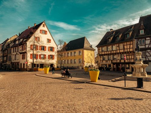 Free Picturesque view of Colmar's old town square featuring historic timber-framed houses and a quaint cobblestone street. Stock Photo