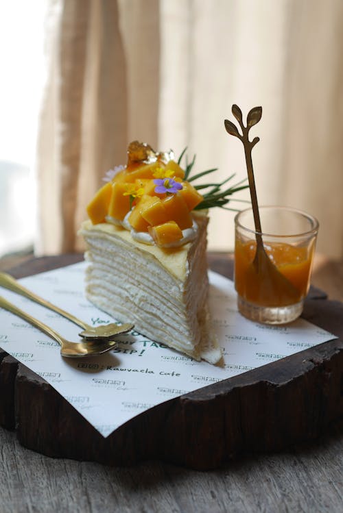 A piece of cake with fruit on top sitting on a wooden table