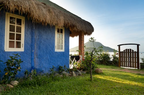 Blue Painted House With Hay Roofing